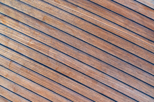 Close up of teak wooden decking on a sailing yacht creating a clean nautical texture and seamless background. Concept of marine design, luxury boating, craftsmanship and premium natural materials.