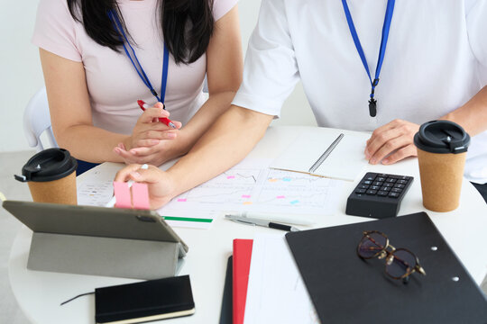 Young Japanese Man and Woman in Casual Clothes Working Together at Table
