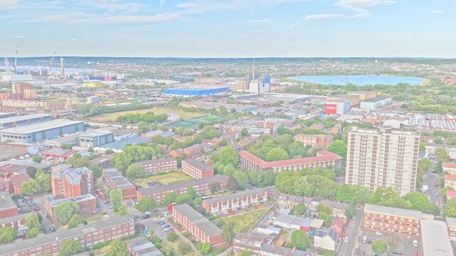 Broadwater Farm Estate spreads across Tottenham, London, with high-rise housing, terraced streets and Lee Valley reservoirs beyond, drone descending.