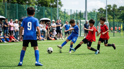 Naklejka premium Young Boys Competing in a Competitive Youth Soccer Match on a Green Artificial Turf Field During a Sunny Day