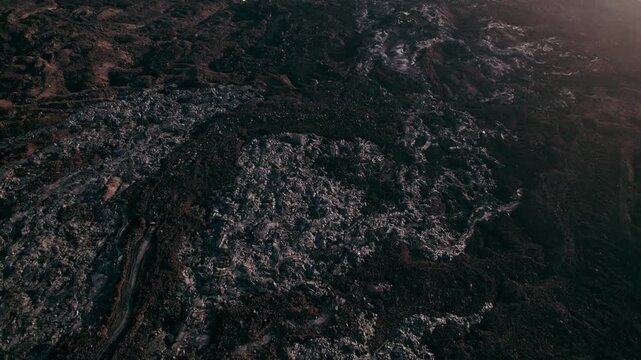 Rugged solidified lava rock forms intricate patterns across the volcanic terrain below.