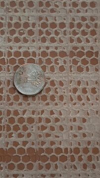 Old Mexican 5 Pesos Coin from 1980 Laid on Brick Surface