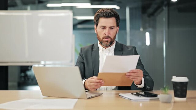 Businessman office space reveals documents from envelope, encountering distressing information. Expresses concern, worry, indicating business challenge or financial setback. Disappointment, problems.
