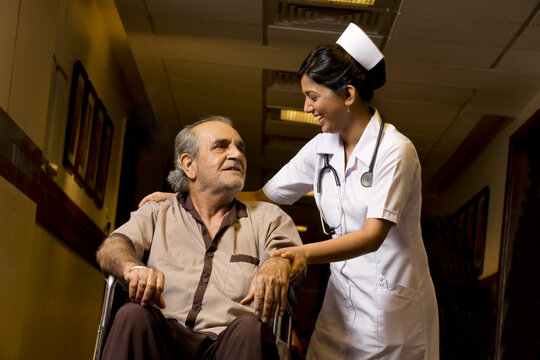 Nurse helping a patient on a wheelchair 