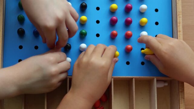 Watch as little hands play joyfully with a vibrant plastic mosaic, fostering fine motor skills and creative thinking. This engaging video captures the essence of playful learning in preschoolers.