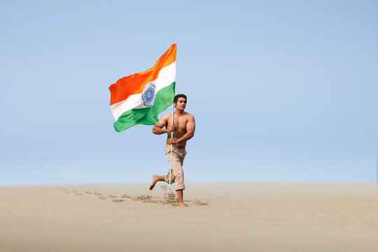 Bare chested man running with the Indian flag 
