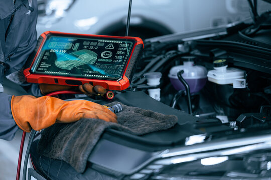 Electric Car Diagnostic Tablet Technology Inspection EV Mechanic Checking Engine Bay Garage Service