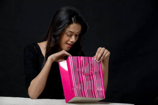 Young woman looking inside a shopping bag 