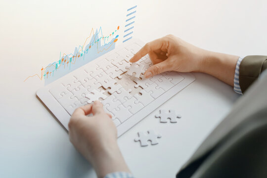 Business professional placing puzzle pieces with a financial growth chart, symbolizing strategic planning, problem solving, business development, teamwork, and achieving long-term success.