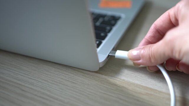 Connecting the USB Type-C cable to the laptop power outlet to charge the battery.