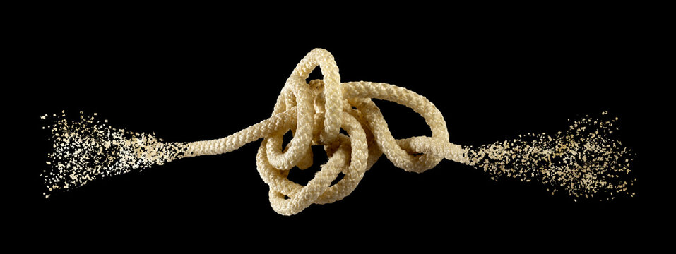 Knot made of rope with dust particles scattering around it in a dark setting