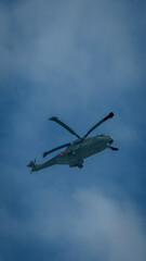 Fototapeta premium Close up Military Helicopter Flying in Blue Sky