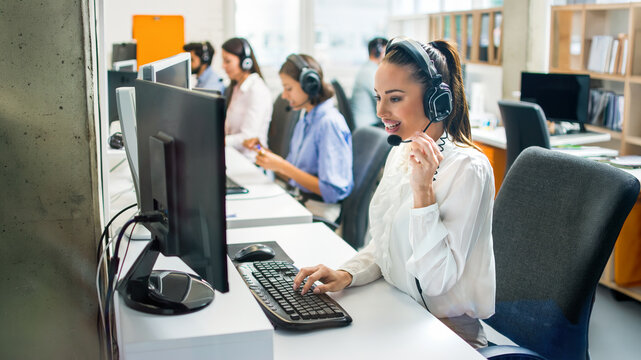 Team of customer support agents working together in busy office