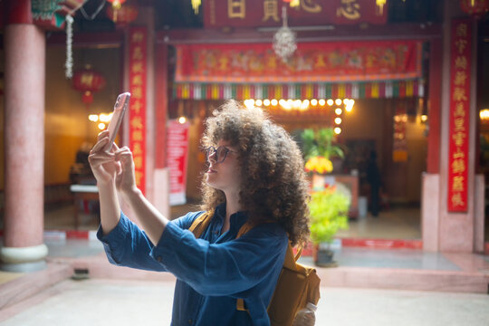 Caucasian Woman Taking Selfie at Chinese Temple During Asian Travel Adventure