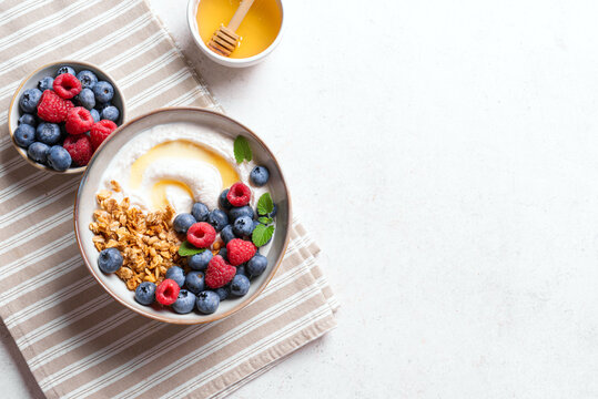 Granola bowl with greek yogurt, berries and honey for healthy breakfast.