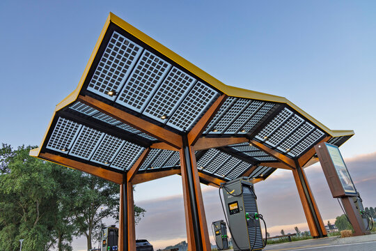 Beesd, Netherlands - 7 August 2026: Close view of Fastned EV fast charging terminal beneath a large solar panel roof canopy.