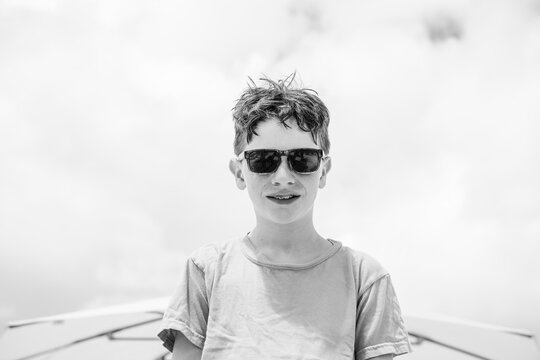 Young boy in sunglasses with braces smiles