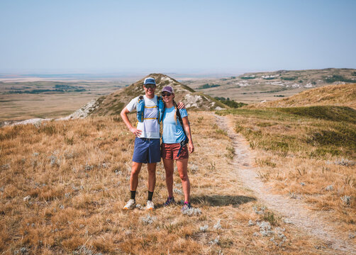 Happy couple posing for photo on a sunny hike