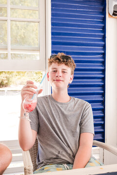 Happy teenage boy enjoys a frozen summer drink