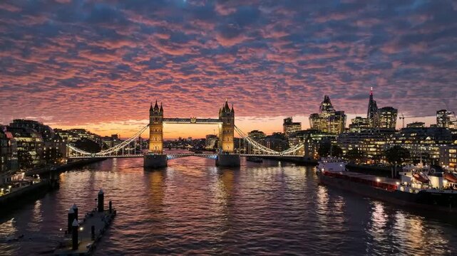 Sunset over tower bridge and london skyline: iconic thames river view with dramatic clouds and city lights at twilight