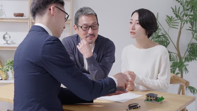不動産購入を考える夫婦と営業マン