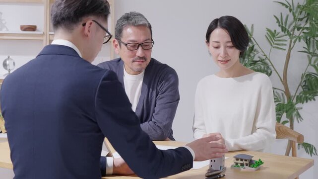 不動産購入を考える夫婦と営業マン