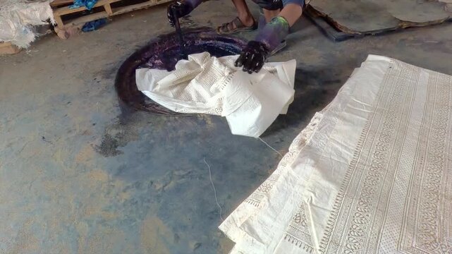 Artisan Dips Dabu Resist-Printed Cotton Fabric Into Indigo Dye Vat in Rajasthan