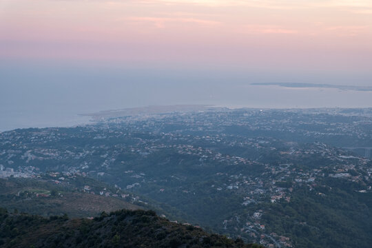A misty twilight view of Nice, France, from the mountains, overlooking the city and the airport runways by the sea
