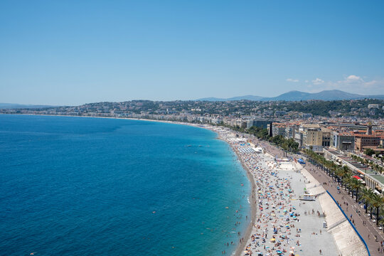 Stunning aerial view of the turquoise Baie des Anges and the crowded pebble beach in Nice, French Riviera