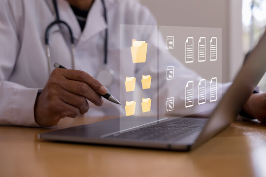 Doctor using laptop with digital medical records and file management interface, representing electronic health data, healthcare technology, patient documentation, secure storage hospital workflow.
