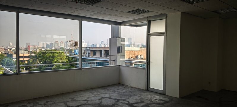 City skyline view from an empty office corner with a frosted glass door