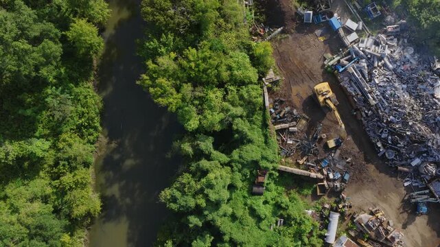 Aerial view of heavy machinery clearing deforested land near river for construction or agriculture