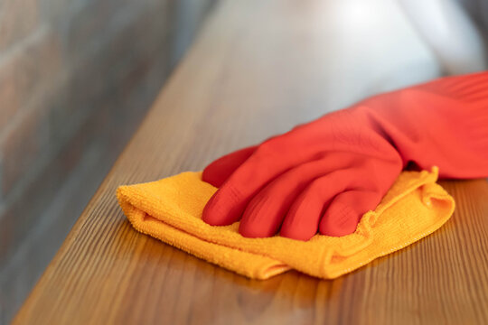 Close up woman cleaning kitchen using cleanser spray and cloth.