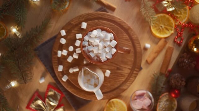 top view of cocoa with marshmallows in mug on wooden table, warm christmas holiday drink with sweets on new year eve, flat lay