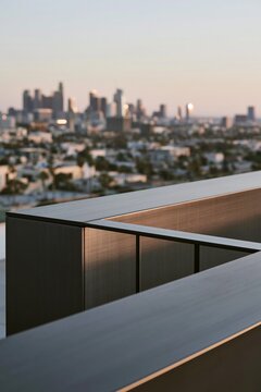 Closeup of matte black metal railing with brushed texture on urban rooftop, city skyline softly blurred in the background during sunset