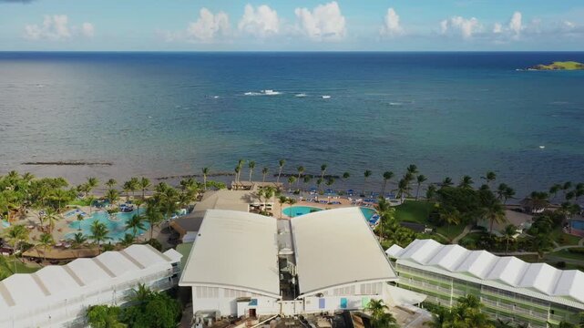 Bird's-eye view of Coconut Bay Resort's oceanfront in Vieux Fort, Saint Lucia, showcasing pools, cabanas, and the shimmering Atlantic reef along the tropical shore.