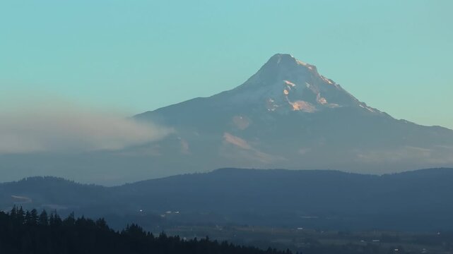 An aerial drone shot zoomed into Mt Hood and nearby towns like Hood River in northern Oregon that pans over to reveal the huge smoke plume billowing from the Grasshopper fire