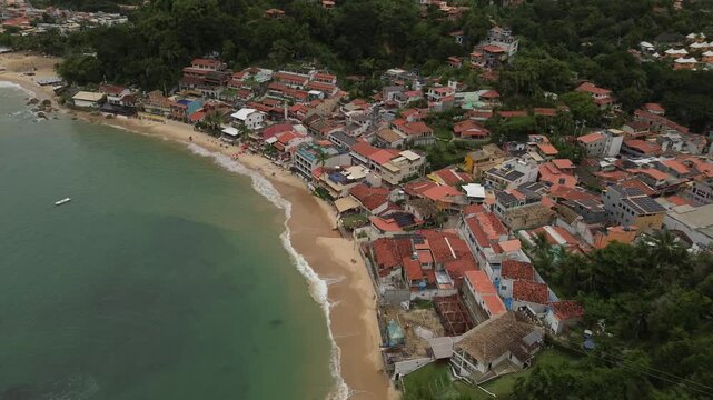 Aerial drone top down to tilt up shot revealing the First Beach and coastal village in Morro de Sao Paulo Bahia Brazil