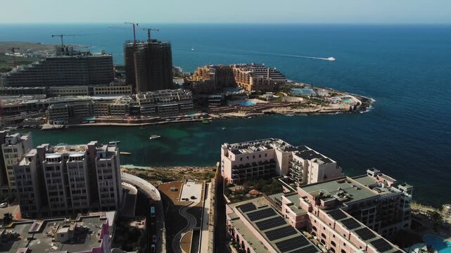 High angle aerial view of coastal of Cyprus with hotel towers, construction cranes, boats.