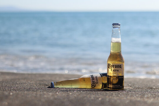 Pomorie, Bulgaria - August 11, 2026: Two bottles of Corona Extra light beer on a sandy beach against the sea background. Refreshing Mexican Corona beer in bottles on the seashore. Vacation concept