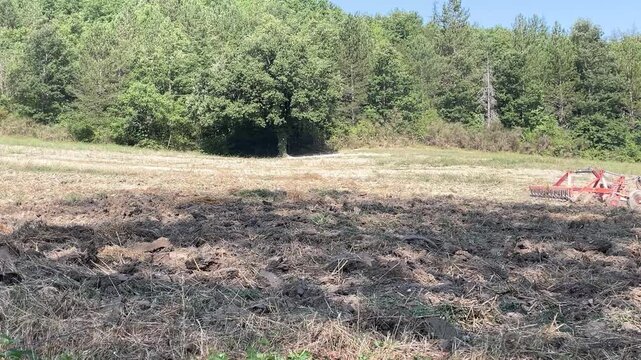 vertical slow-motion video of agricultural cultivator tilling soil. themes of agricultural labor, seasonal preparation, and the vital work involved in crop production