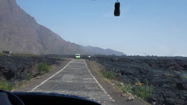 Driving on Road Between Lava Rocks and Fields on Fogo Island, Cape Verde, Backseat Car Point of View