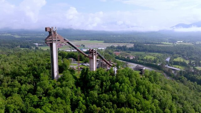 Drone descends past the Lake Placid Olympic ski jumps toward the river valley