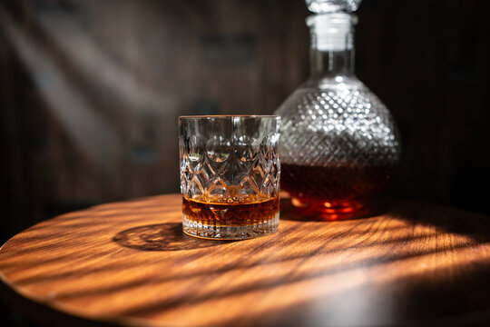 Whiskey Glass and Crystal Decanter on Wooden Table