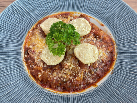 Plate of spaghetti with meatballs, tomato sauce, shredded cheese, and fresh parsley, showcasing a comforting Italian-style pasta meal.