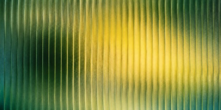 Abstract green fluted glass texture with vertical lines and soft yellow light, ribbed glass surface with blurred gradient background, decorative architectural glass panel for modern interior