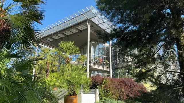 A view of the Palm House building in Gliwice, Poland. Gliwice's municipal palm house. A tourist attraction in Upper Silesia. The building is located in a park surrounded by trees and palms.