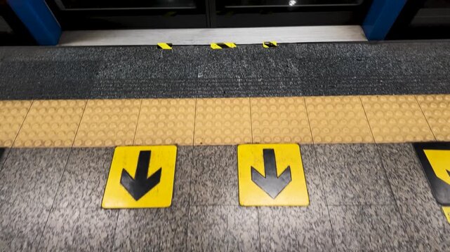 Yellow Directional Floor Arrows at Bangkok Subway Station Platform