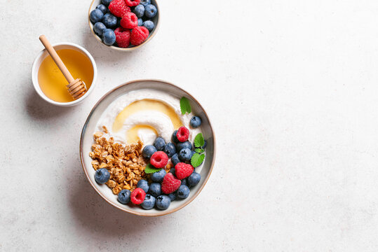 Granola bowl with greek yogurt, berries and honey for healthy breakfast.