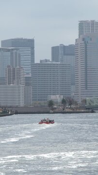 Boat Navigating Sumida River with Tokyo Skyline and Skyscrapers